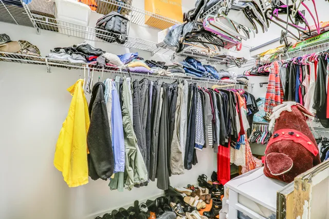 a view of walk in closet with clothes and shoes