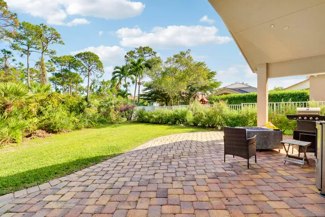 a view of a patio with a table and chairs under an umbrella