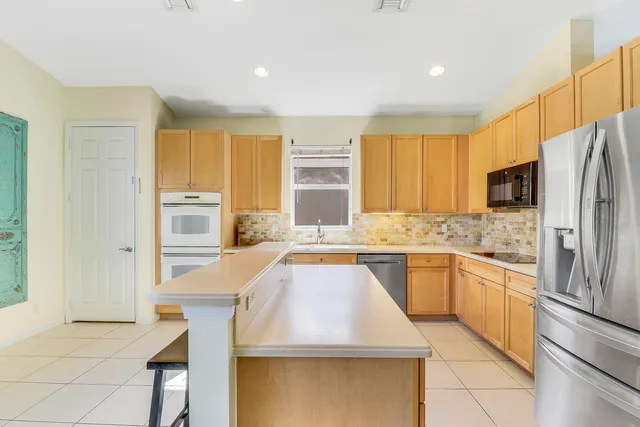 a kitchen with stainless steel appliances granite countertop a sink and a refrigerator