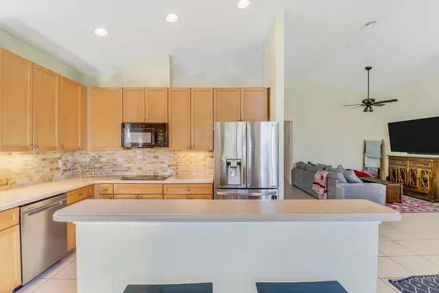 a kitchen with kitchen island granite countertop a sink a stove and a refrigerator