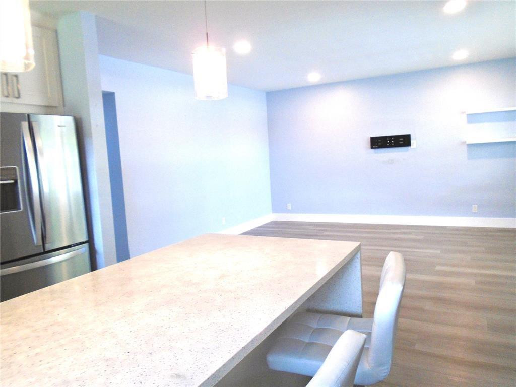 1991 Northeast 32nd Street, Unit 18 Lighthouse Point, FL 33064 - Photo 20 of 39 a view of a kitchen with stainless steel appliances wooden floor and chair
