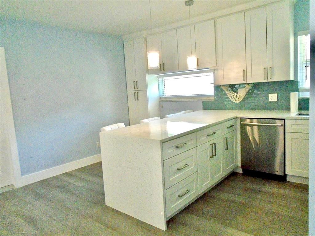 1991 Northeast 32nd Street, Unit 18 Lighthouse Point, FL 33064 - Photo 21 of 39 a kitchen with white cabinets and sink