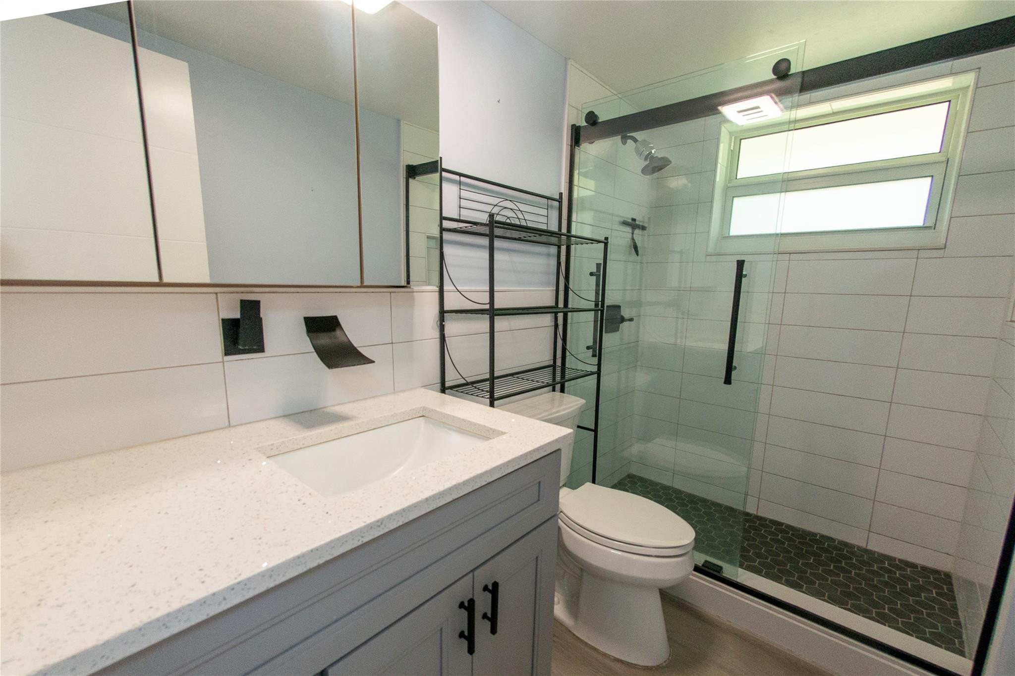 1991 Northeast 32nd Street, Unit 18 Lighthouse Point, FL 33064 - Photo 22 of 39 a bathroom with a sink a toilet and shower
