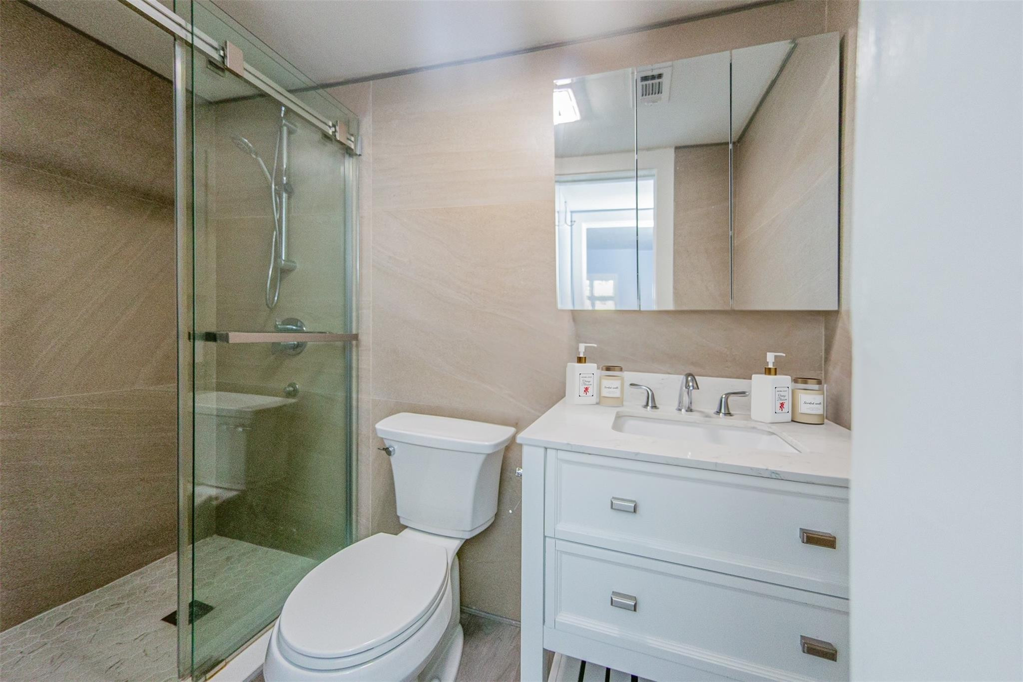 1991 Northeast 32nd Street, Unit 18 Lighthouse Point, FL 33064 - Photo 24 of 39 a bathroom with a toilet a sink a vanity and shower