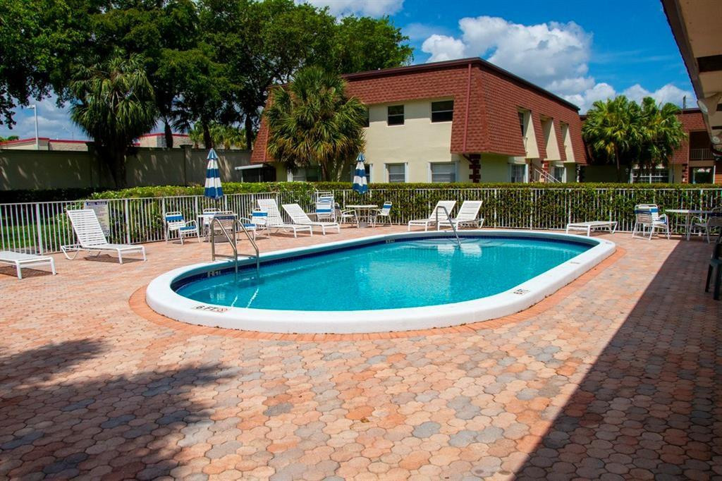 1991 Northeast 32nd Street, Unit 18 Lighthouse Point, FL 33064 - Photo 34 of 39 a view of a house with swimming pool and a yard