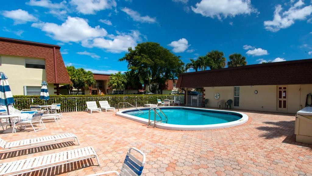 1991 Northeast 32nd Street, Unit 18 Lighthouse Point, FL 33064 - Photo 35 of 39 a view of a swimming pool with a patio