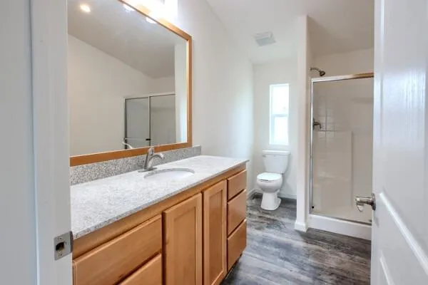 a bathroom with a granite countertop sink toilet and shower curtains