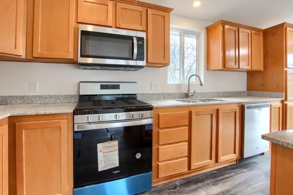 43555 Highway 41, Unit 53 Oakhurst, CA 93644 - Photo 7 of 28 a kitchen with granite countertop cabinets stainless steel appliances and wooden floor