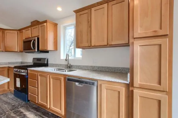 a kitchen with stainless steel appliances granite countertop a sink and a microwave