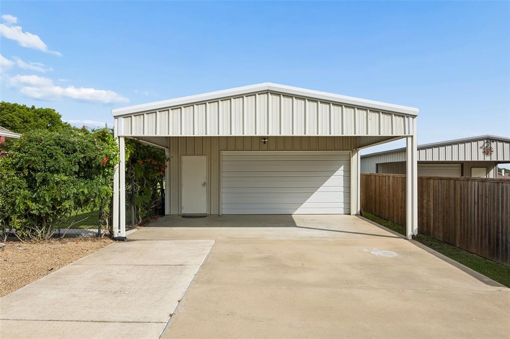 11211 Emerald Ranch Lane Forney, TX 75126 - Photo 4 of 35 Detached metal garage with an overhead door, adjacent side entry, and an integrated carport
