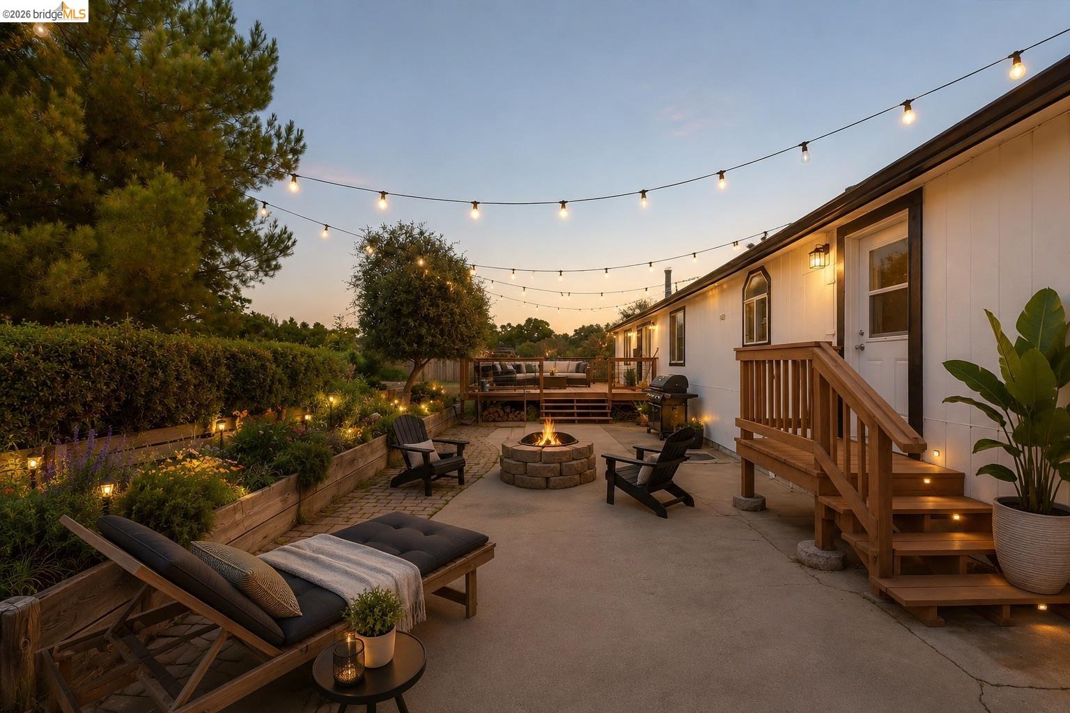 4419 Little John Road Copperopolis, CA 95228 - Photo 22 of 43 Expansive concrete patio featuring a stone fire pit, string lighting, and direct access to an elevated wood deck