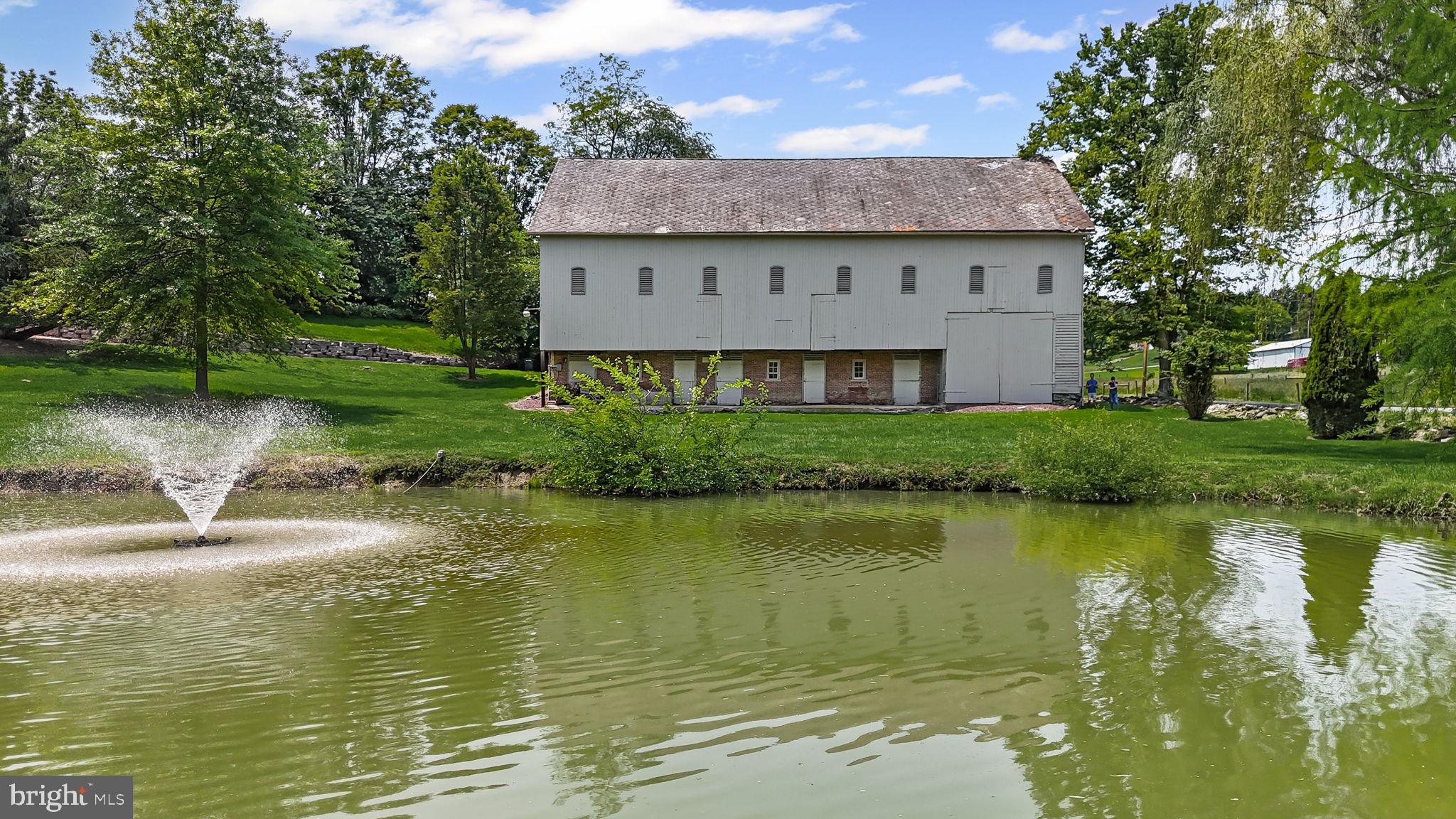 154 Calvary Church Road Wrightsville, PA 17368 - Photo 11 of 89 a view of a large building next to a lake with a large trees