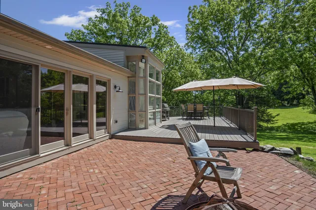 a kitchen with stainless steel appliances granite countertop a dining table chairs refrigerator and cabinets