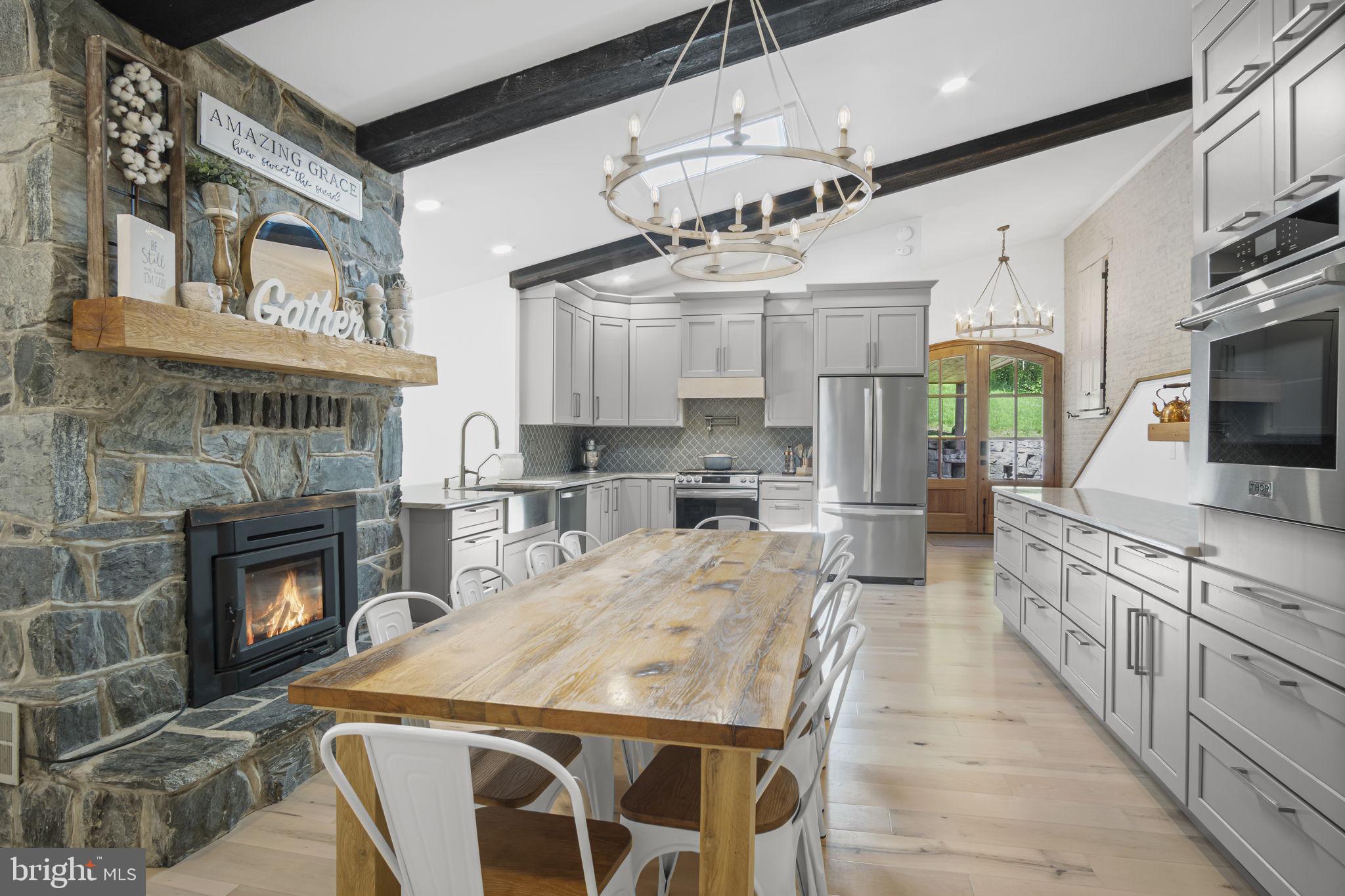 154 Calvary Church Road Wrightsville, PA 17368 - Photo 28 of 89 a kitchen with stainless steel appliances kitchen island granite countertop a stove top oven a sink dishwasher and a fireplace with wooden floor