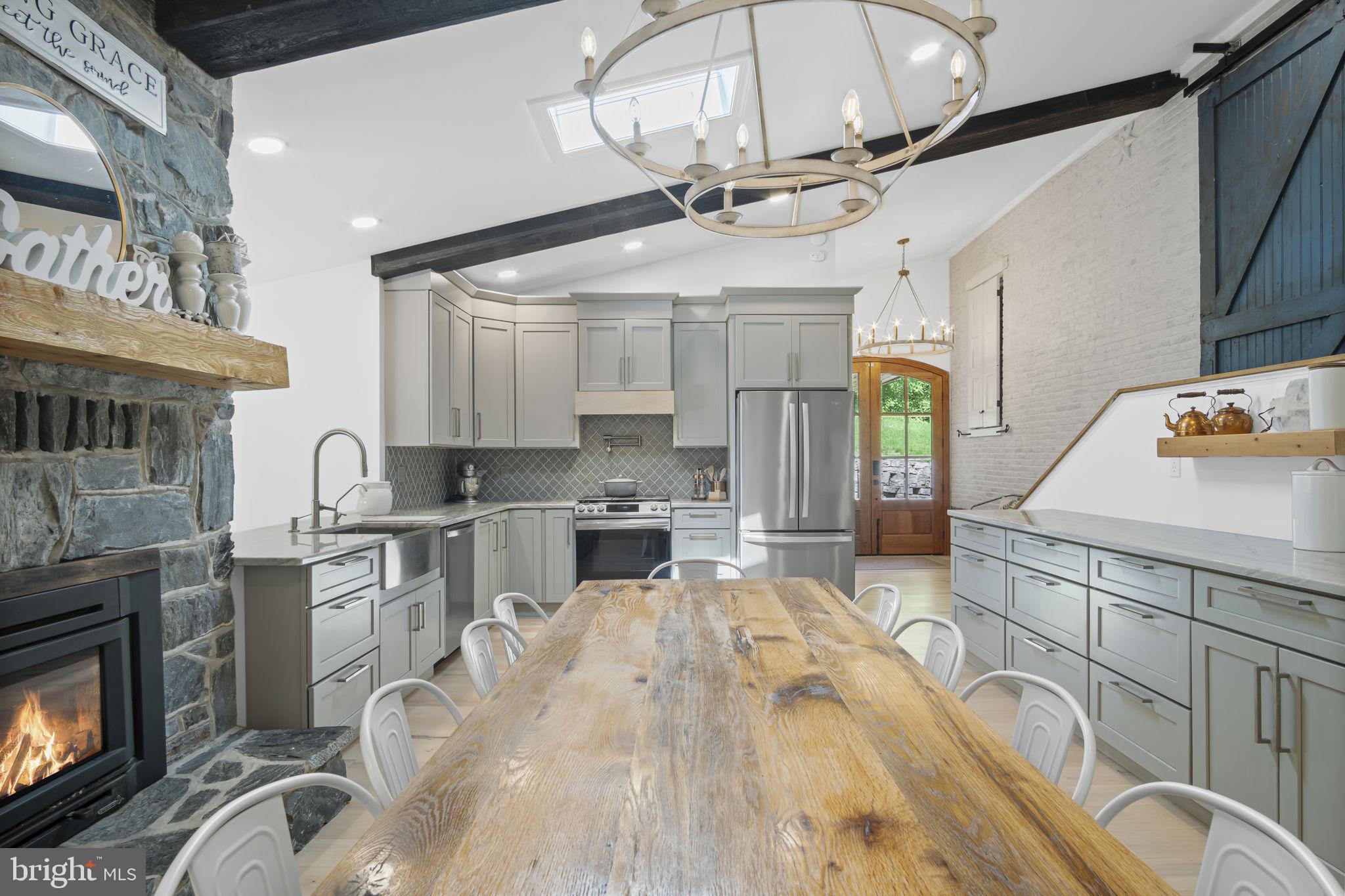 154 Calvary Church Road Wrightsville, PA 17368 - Photo 31 of 89 a kitchen with stainless steel appliances kitchen island granite countertop a stove a sink a dining table and chairs with wooden floor