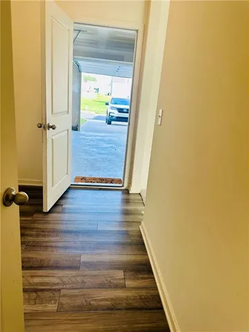 a view of a hallway with wooden floor and staircase