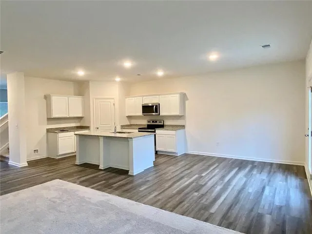 a kitchen with a refrigerator and white cabinets