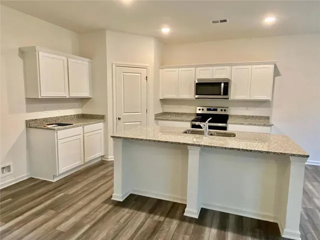 a kitchen with stainless steel appliances a stove a sink and a microwave