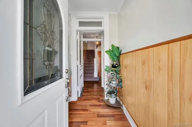 a view of a hallway with wooden floor and a dining room view