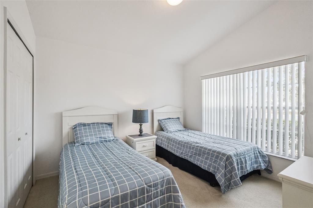 1202 Winding Cypress Court Kissimmee, FL 34746 - Photo 20 of 41 a bedroom with two beds and a night stand