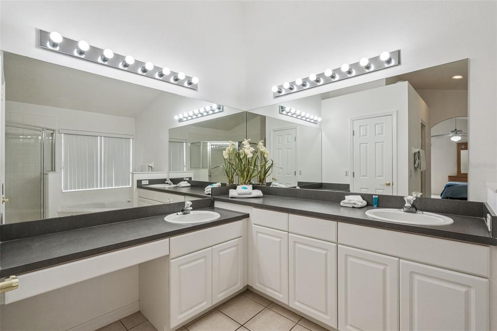 1202 Winding Cypress Court Kissimmee, FL 34746 - Photo 22 of 41 a bathroom with double vanity and a mirror