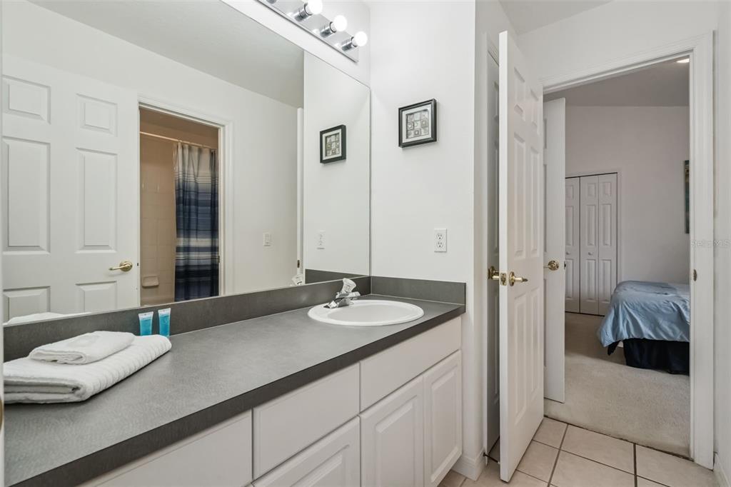 1202 Winding Cypress Court Kissimmee, FL 34746 - Photo 23 of 41 a bathroom with a granite countertop sink and a mirror