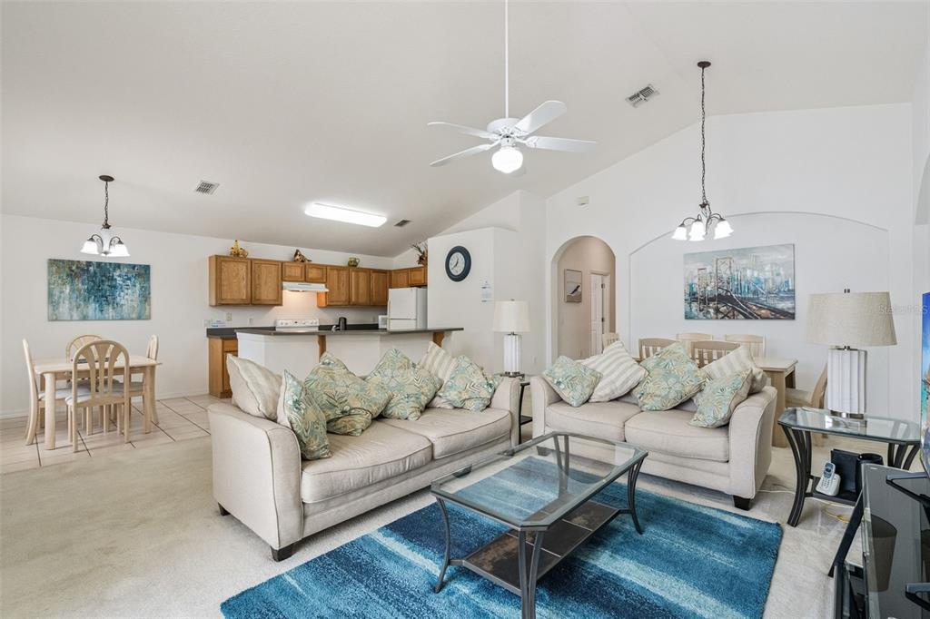 1202 Winding Cypress Court Kissimmee, FL 34746 - Photo 5 of 41 a living room with furniture kitchen view and a chandelier