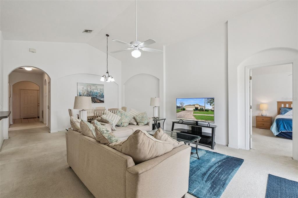 1202 Winding Cypress Court Kissimmee, FL 34746 - Photo 7 of 41 a living room with furniture and a chandelier