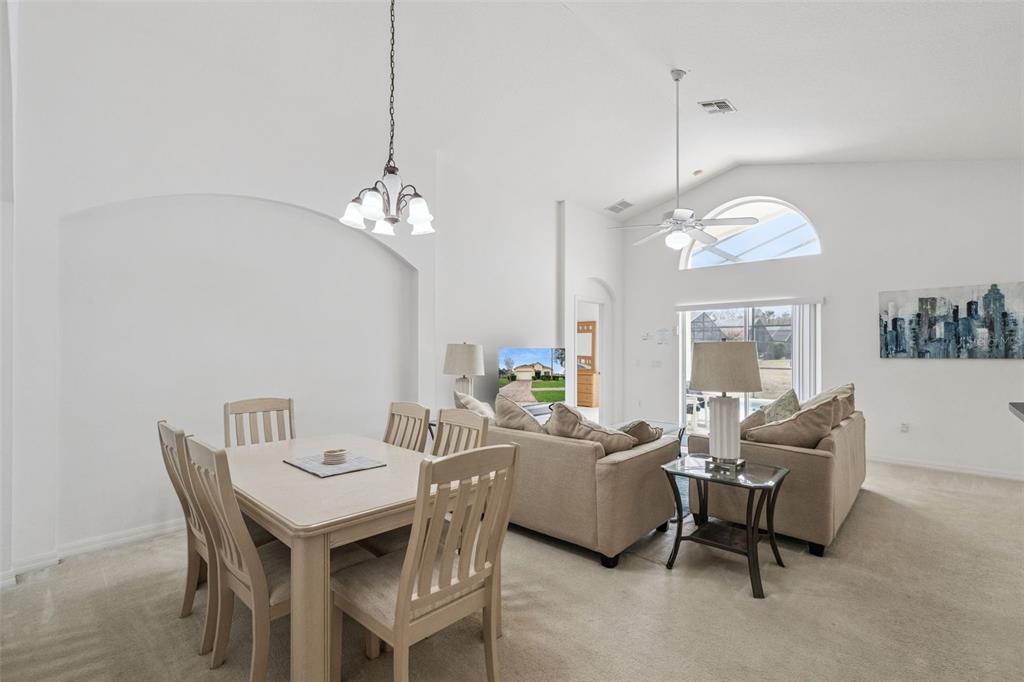 1202 Winding Cypress Court Kissimmee, FL 34746 - Photo 8 of 41 a living room with furniture a chandelier and a mirror