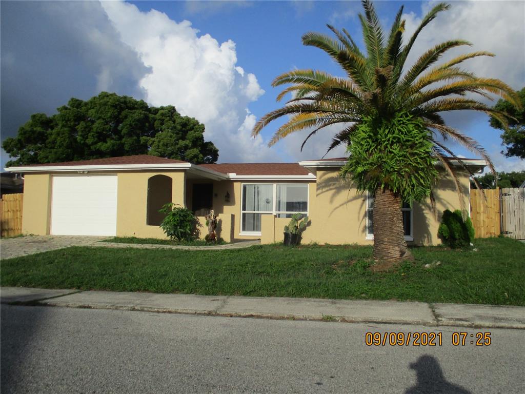 9135 Hunt Club Lane Port Richey, FL 34668 - Photo 1 of 1 a front view of a house with a garden and a yard