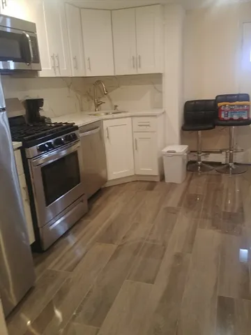 a kitchen with a stove and white cabinets