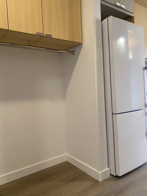 154 Broadway, Unit 507 Somerville, MA 02145 - Photo 13 of 31 a view of a room with wooden floor and cabinets