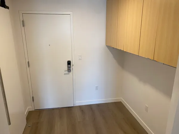 a view of a kitchen with wooden floor and electronic appliances