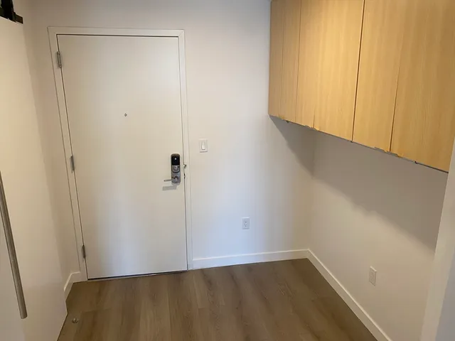a view of a kitchen with wooden floor and electronic appliances