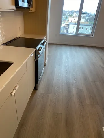 a kitchen with stainless steel appliances a stove a microwave and white cabinets