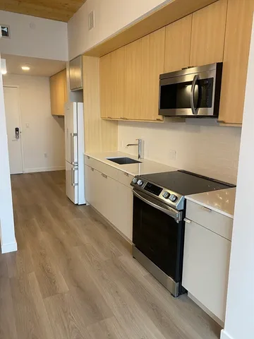 a kitchen with stainless steel appliances granite countertop a stove a microwave and a refrigerator