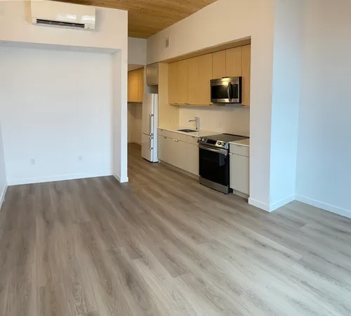 a view of a kitchen with a sink wooden floor and a window