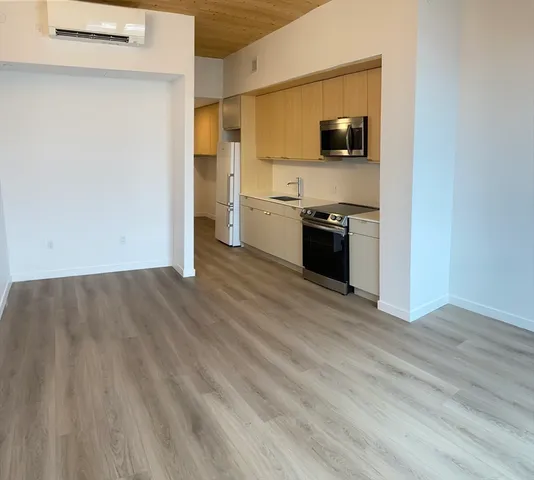 a view of a kitchen with a sink wooden floor and a window