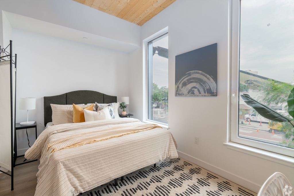 154 Broadway, Unit 507 Somerville, MA 02145 - Photo 6 of 31 a bedroom with a bed and glass window