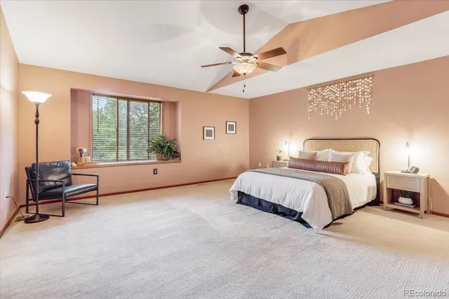 a spacious bedroom with a bed and a chandelier