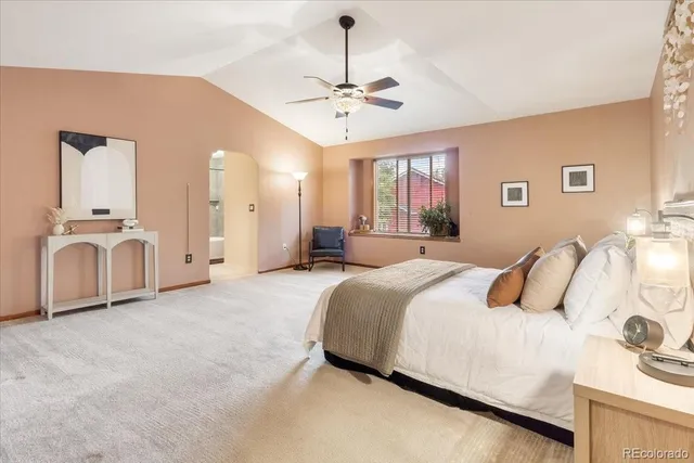 a spacious bedroom with a bed and a chandelier