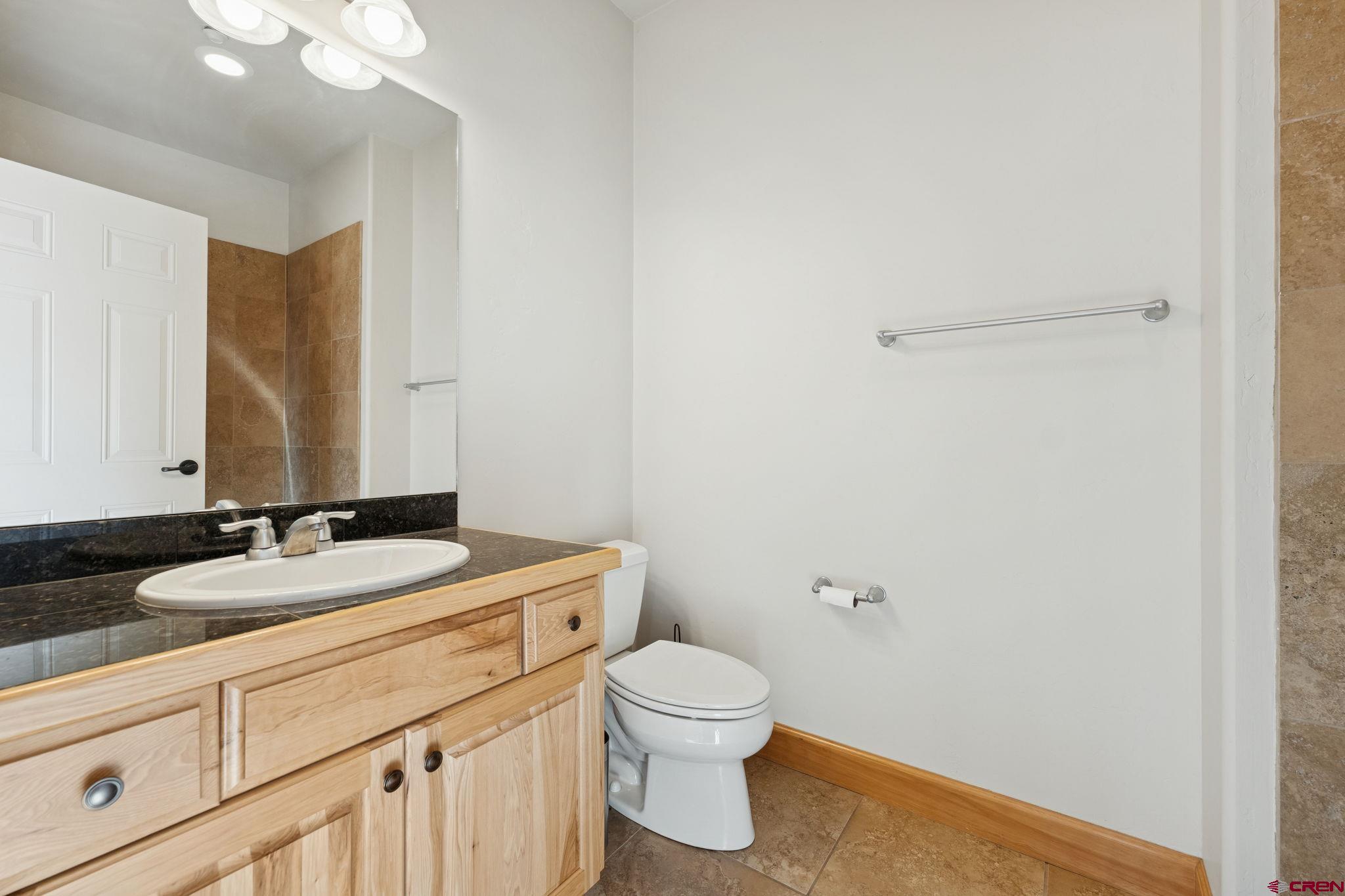 1422 Animas View Drive, Unit 55 Durango, CO 81301 - Photo 30 of 44 a bathroom with a granite countertop toilet sink mirror and vanity