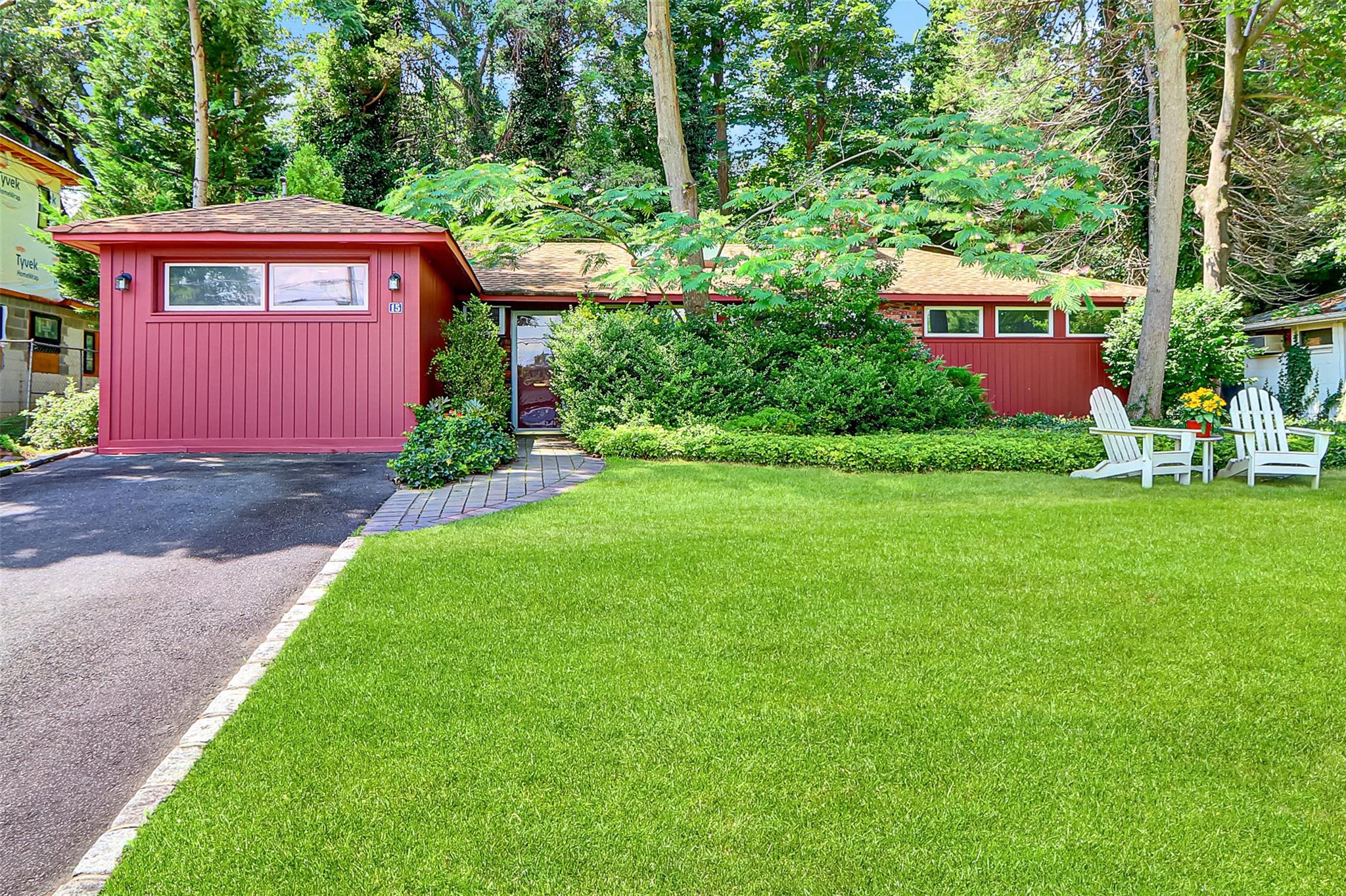 a red brick house with a big yard and large trees