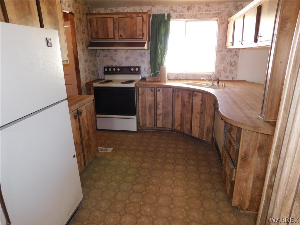 3539 Mobile Road Golden Valley, AZ 86413 - Photo 10 of 18 a kitchen with a stove a refrigerator and a sink
