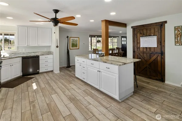 a large kitchen with stainless steel appliances granite countertop a stove oven and a refrigerator