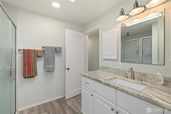 a bathroom with a granite countertop sink and a mirror