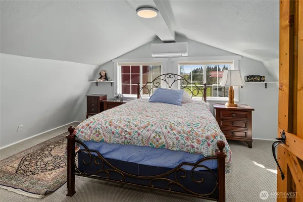 a bedroom with a bed a table and painting