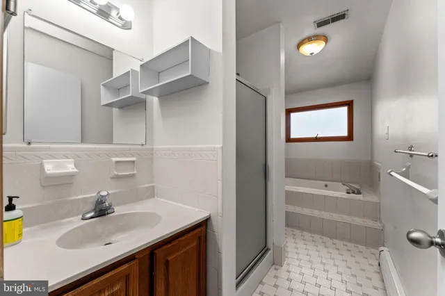 a bathroom with a sink vanity tub and a mirror