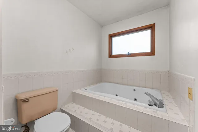 a white toilet sitting next to a bath tub