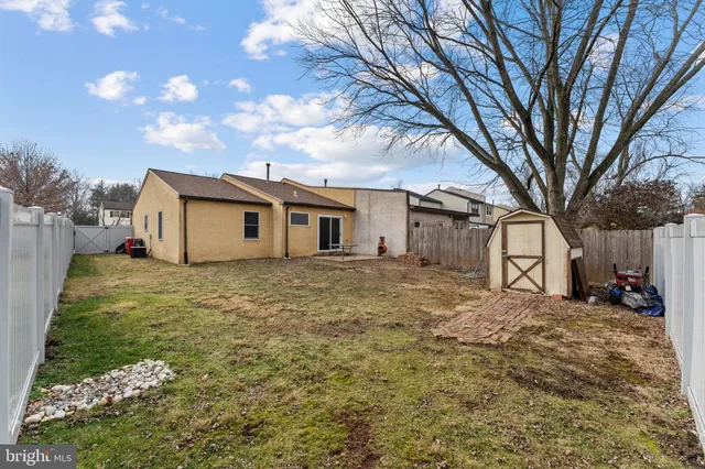 a backyard of a house with large trees and table and chairs